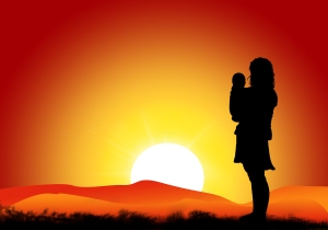 Un bebé y su mamá en una puesta de sol. Fuente: freeimages